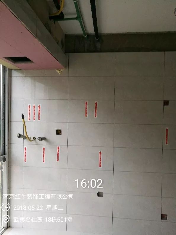南京武夷名仕園124平米簡美風(fēng)格裝修  享受家?guī)淼臏囟?0五月份_墻磚鋪貼完成后，紅牛裝飾的工人會用專用護(hù)角條對瓷磚角保護(hù)，用標(biāo)貼標(biāo)出水管、線管走向示意。